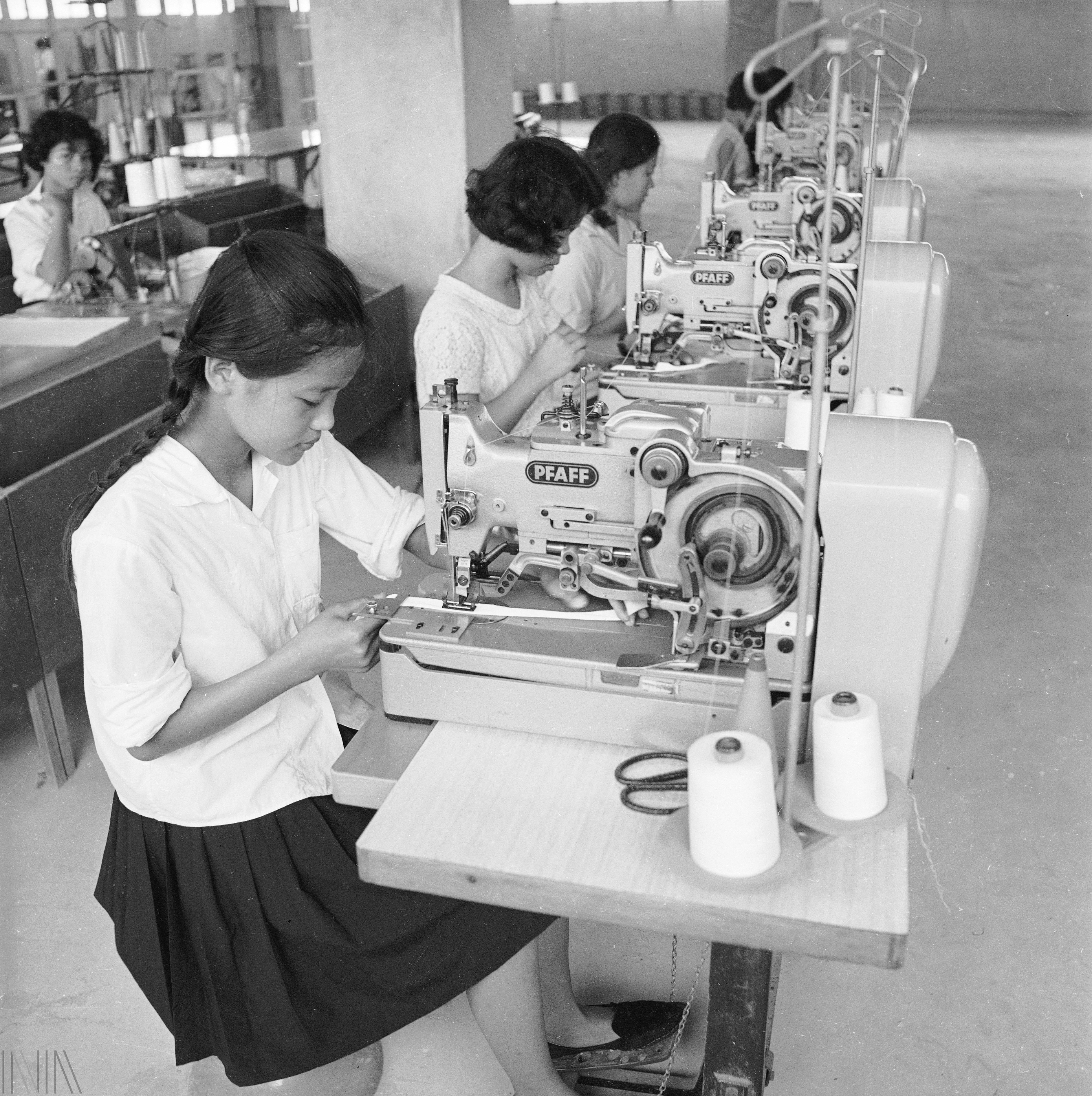 刊頭 年少的女性作業員在製衣廠裡縫紉成衣