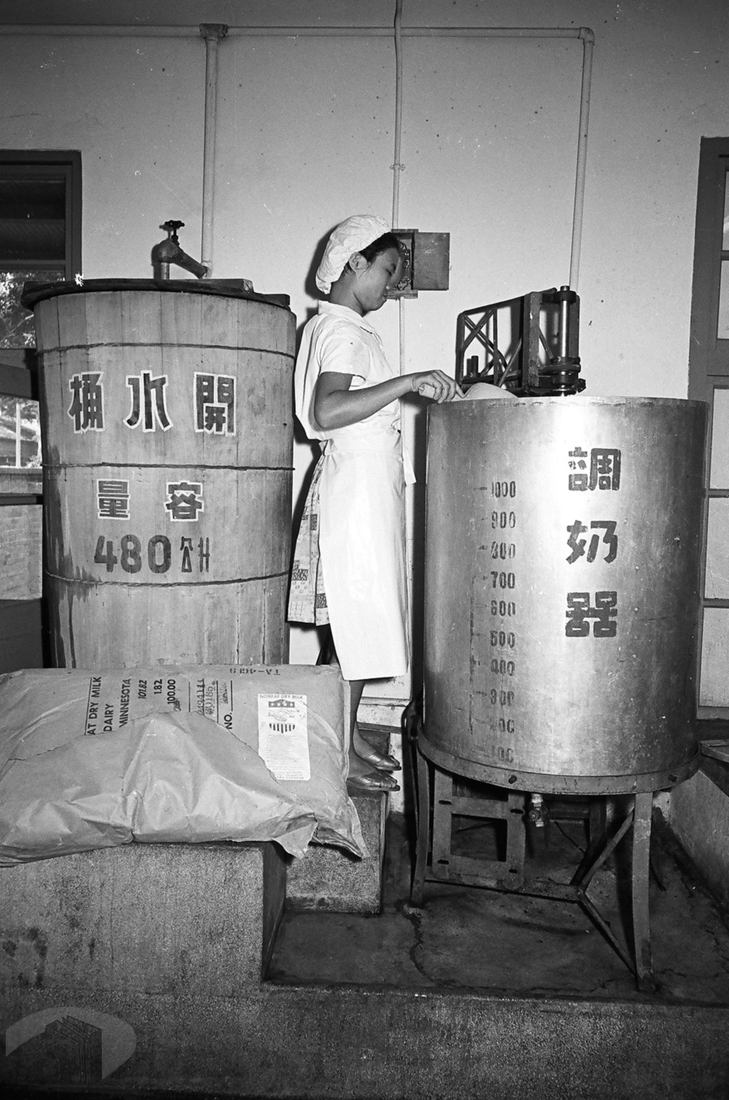 圖8 廚工操作調奶器，將脫脂奶粉與熱水依比例混合調製