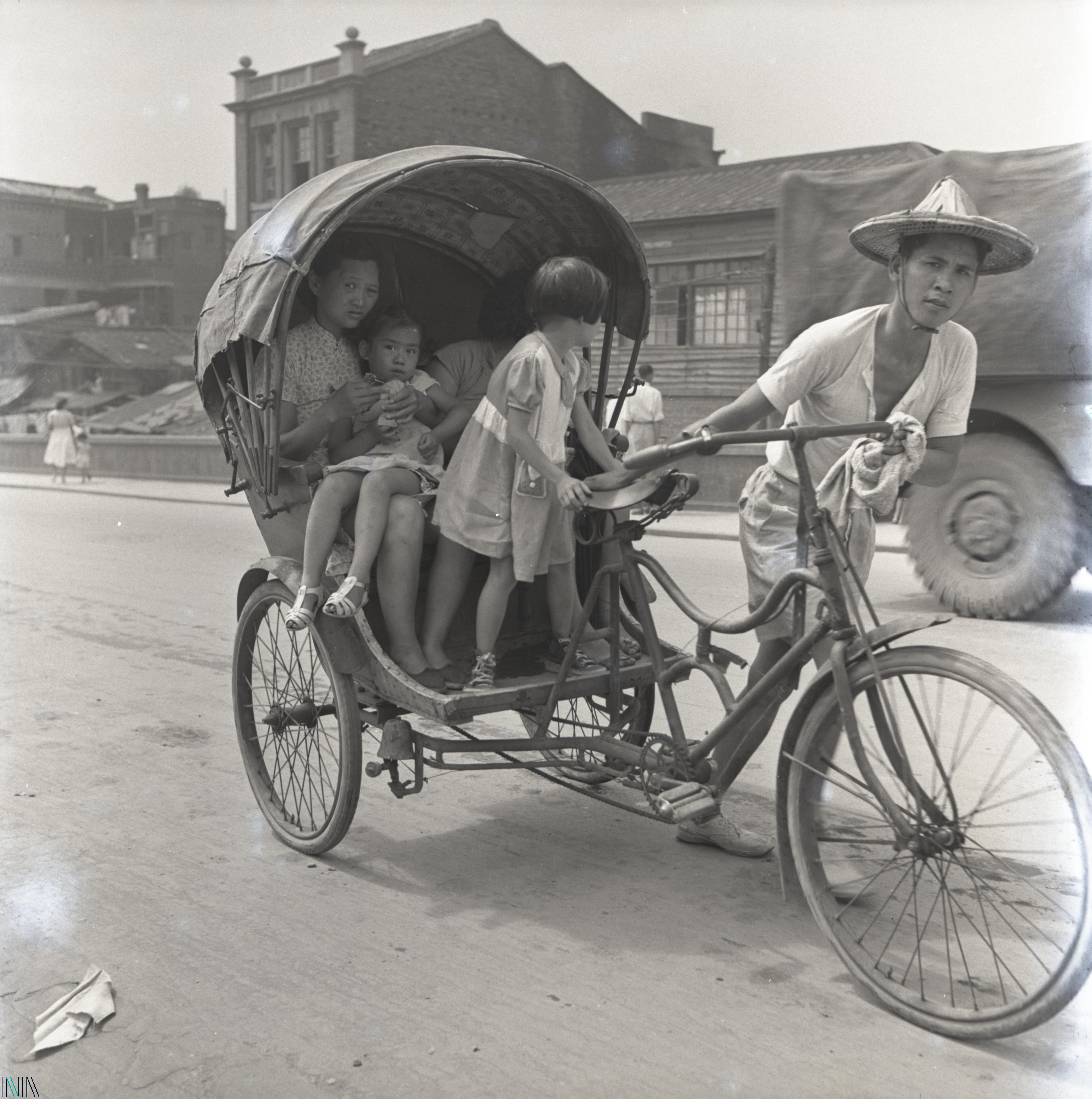 圖4 1950年代三輪車伕拉著承載大人、小孩的三輪車照片