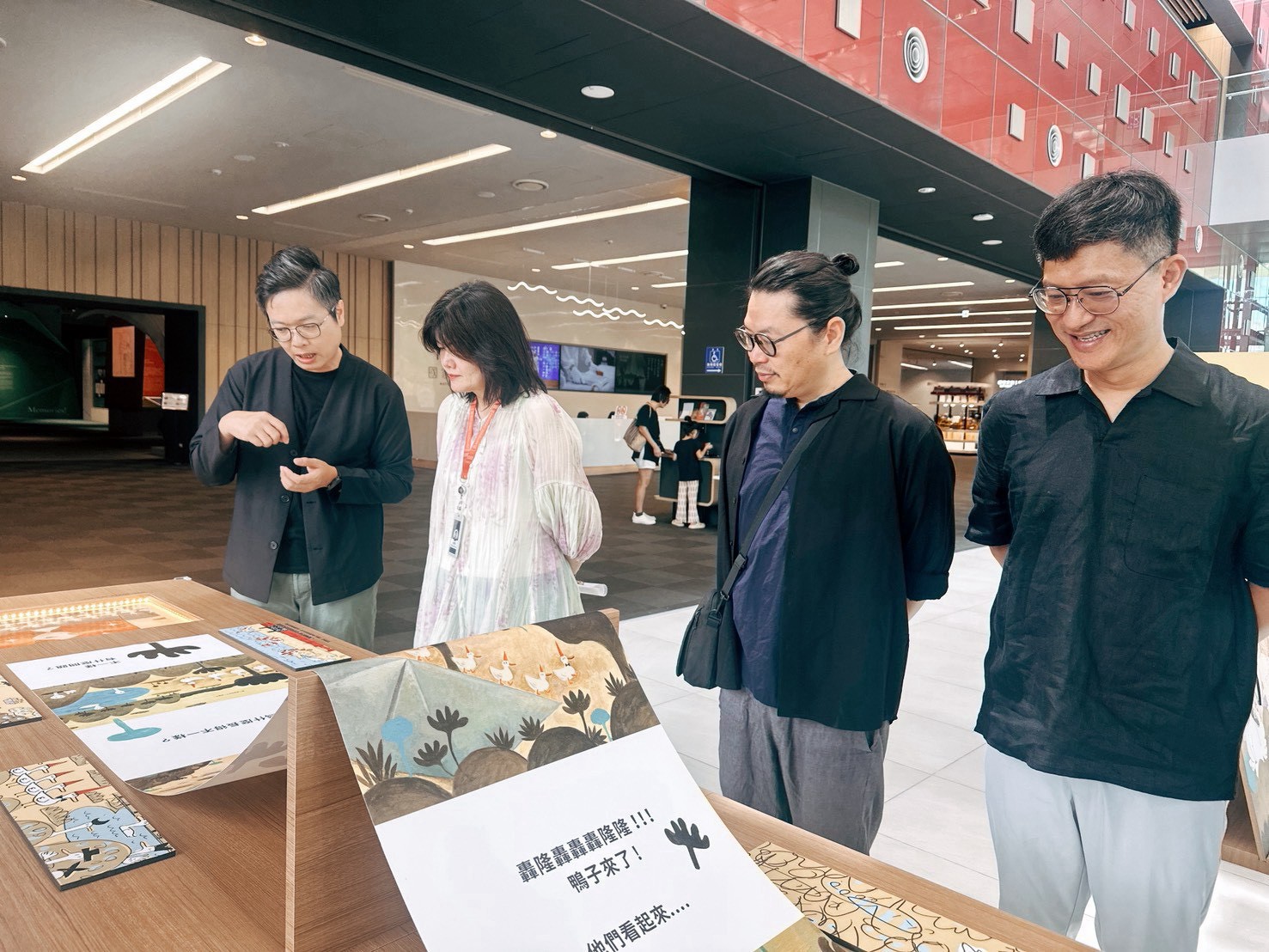 圖4 目目文創總監楊欽榮(左一)向檔案局局長莊明芬(左二)、創作者周見信(右二)、郭乃文(右一)介紹原稿及草圖展區